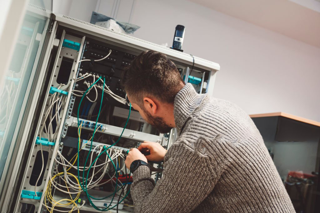 IT engineer in the server room connecting cables