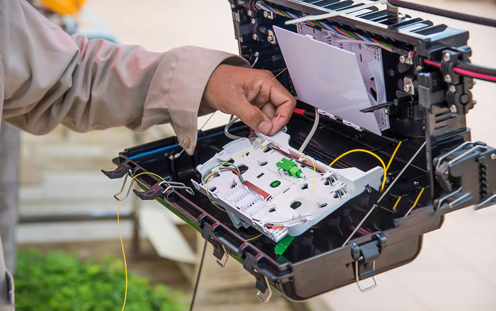 Technicians are install cabinet on fiber optic cable.Blur images with back lighting.