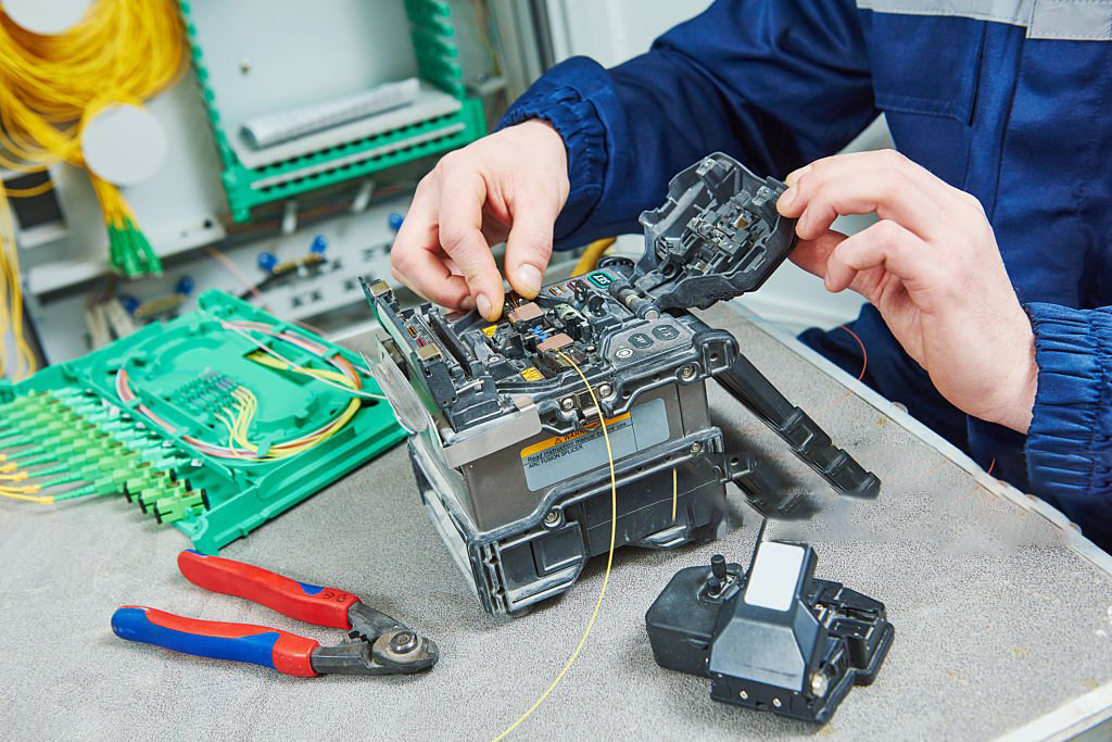 technician engineer working with arc fusion splice machine while connecting fiber optic cable